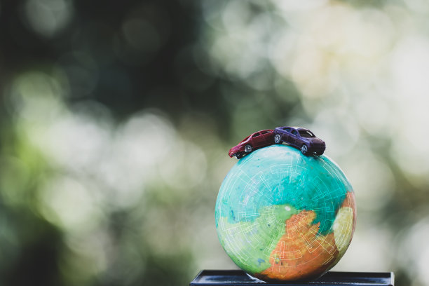 环保拯救世界的理念。红色汽车模型地球粘土与雷达尺度平衡在自然背景。通过减少能源消耗来维护地球，环游世界图片下载