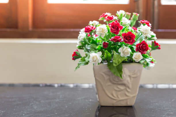 白色和红色玫瑰花束在小花瓶和温暖的灯光背景图片下载