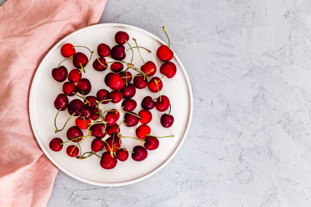白色盘子里的甜樱桃。图片下载