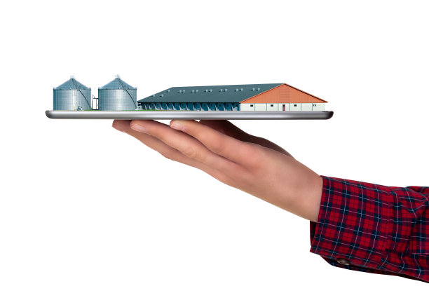 Farmer拿着一个平板电脑和一个现代智能农场图片下载