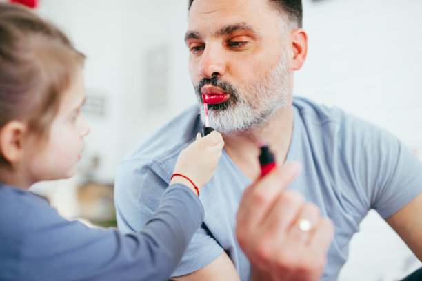 小女孩给爸爸化妆。图片下载