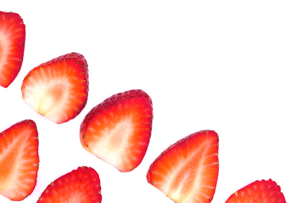 白色背景上孤立的切片草莓盘。白色背景上的草莓。红色草莓片整齐地排列在白色的背景上。图片下载