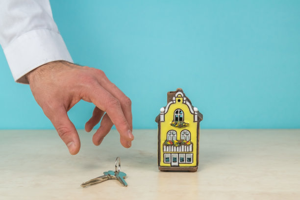 房子模型和钥匙在手，房地产概念，绿松石颜色，复制空间。图片下载