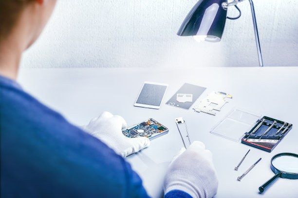 修理工用镊子拆卸智能手机。维修智能手机，服务中心，技术员，手机。图片下载