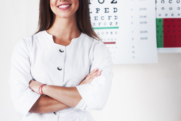 裁剪照片美丽的女眼科医生站在背景板与字母图片下载