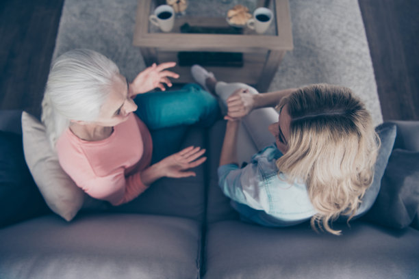 近，在上面，在高角度，观看照片，两个美丽的她，她的女士们的妈妈，孙女，奶奶，热饮料，茶几，讲，讲，说秘密，生活故事，坐在舒适的沙发，沙发，沙发，房子，室内图片下载