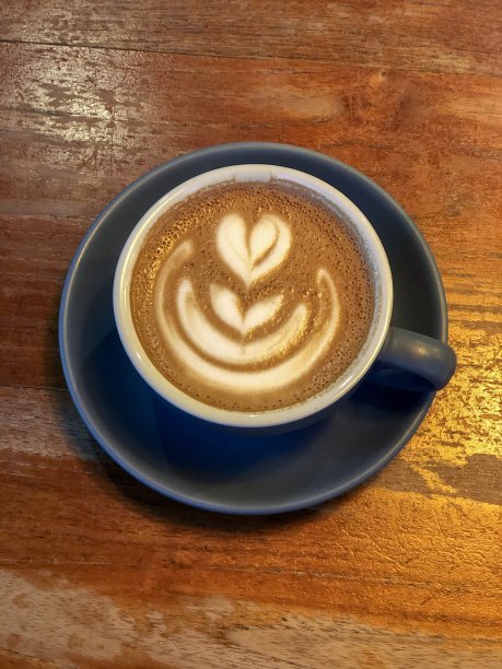 木桌上放着咖啡和拿铁艺术图片下载