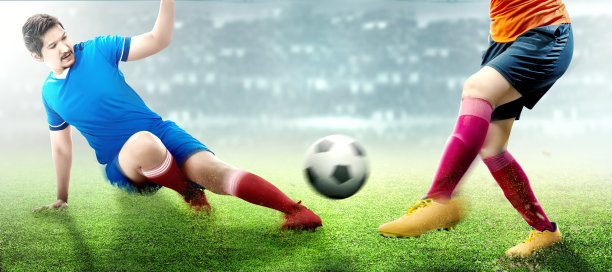 亚洲足球运动员男子在蓝色球衣滑截球从他的对手图片下载