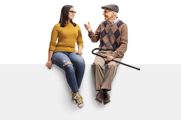 一个资深的男人坐在一个小组里和一个年轻的女孩聊天图片下载