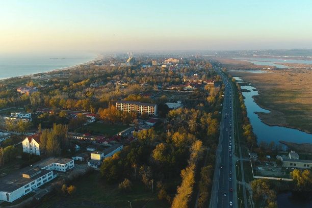 美丽的海滨城市的夜景与道路和潮湿的草地。航拍照片。图片下载