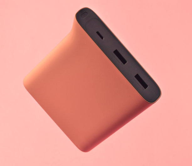 粉色背景上的粉色电源。外接电池用于小玩意。悬浮的对象。图片下载