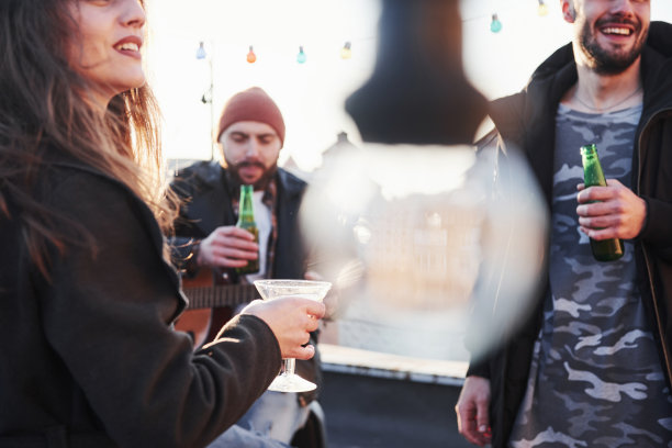 三个朋友，喝酒，弹吉他。照片中央模糊不清的灯泡图片下载