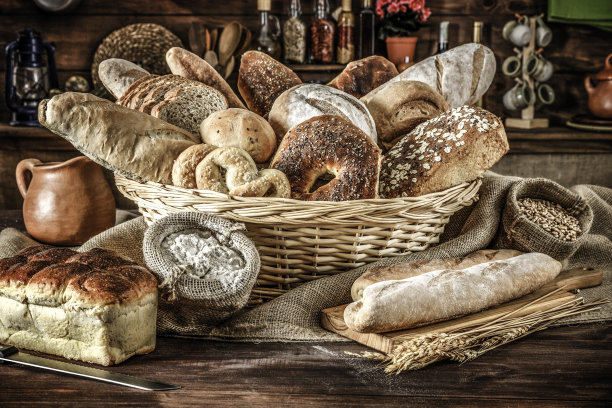 手工烘焙:在乡村厨房里的新鲜混合面包、面包卷和配料图片下载