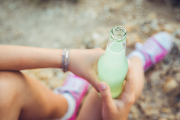在海边喝苏打水的年轻女子图片下载