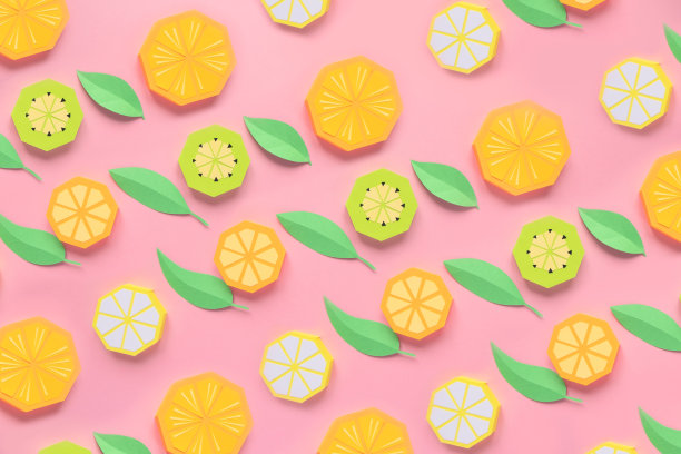 纸做的水果。粉红色的背景。有写作的空间。热带地区。平的。橙、柠檬。图片下载