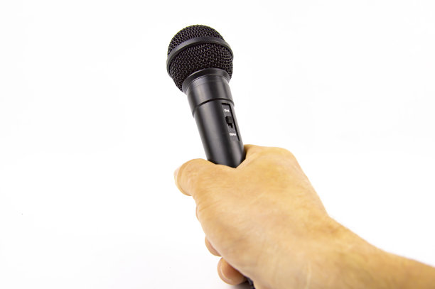 白人背景下，一名男子手持黑色麦克风。图片下载