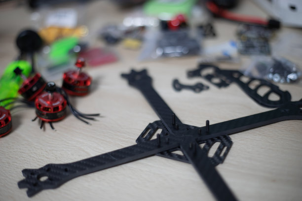 赛车无人机框架被安装在木桌上，背景上有模糊的工具图片下载