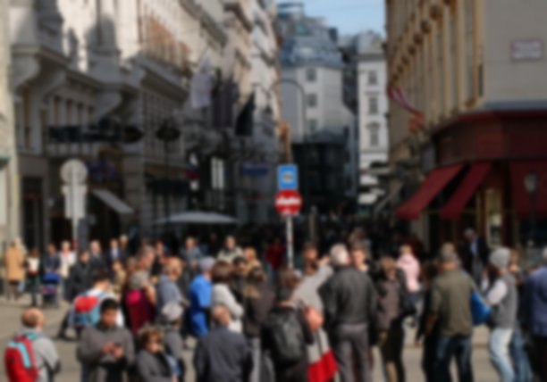 不同的无名人群走在维也纳繁忙的城市街道上，模糊了图片下载