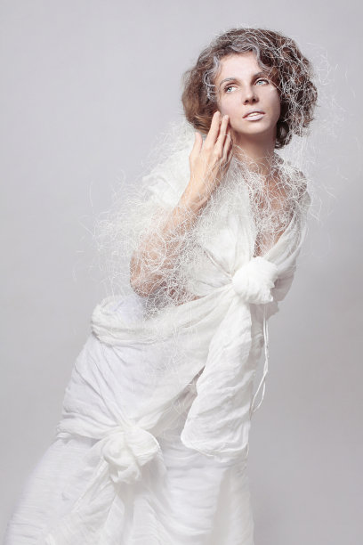 一个女孩的艺术照片，在一个白色的背景上，一个高级定制服装的花哨的白色棉布连衣裙在一个孤立的白色背景图片下载