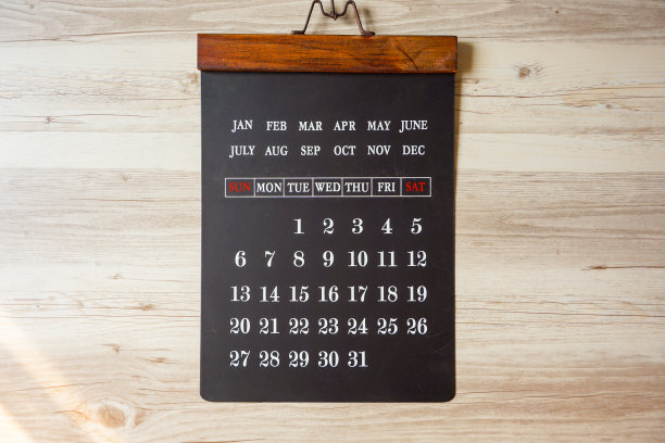 黑板式挂历悬挂在木纹墙上。图片下载
