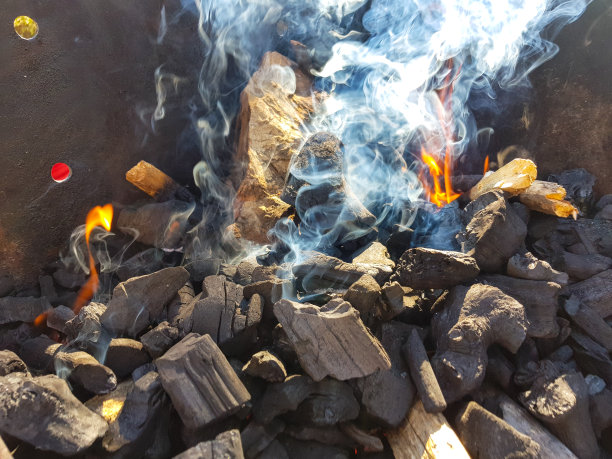 煤块在余烬上产生的烟。为烧烤余烬准备火。户外娱乐。图片中可以看到火焰。图片下载
