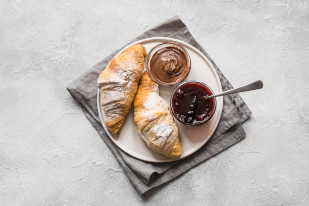 新鲜烤的牛角面包配上浆果酱。前视图。图片下载