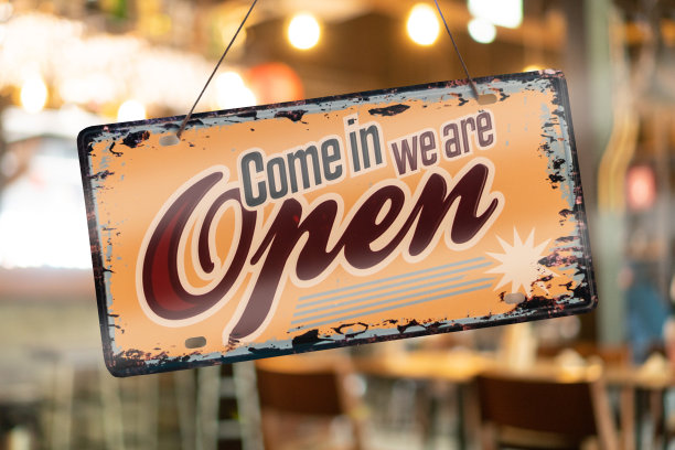 在入口处的门上挂着一个商业标志，上面写着营业的咖啡馆或餐馆。复古色调风格。图片下载