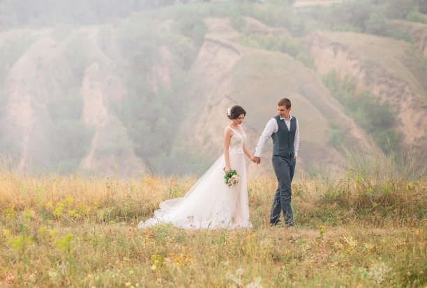 结婚的那一天。时髦的年轻夫妇走在野生动物的背景在日落。不错的照片图片下载