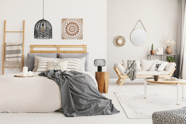 温暖民族客厅和卧室米色斯堪的纳维亚沙发和大床与灰色毯子，真实照片图片下载