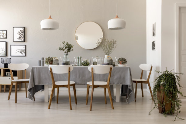 餐桌与新鲜的植物，玻璃器皿，蜡烛和白色椅子在客厅内部的真实照片画廊，灯和镜子在墙上图片下载