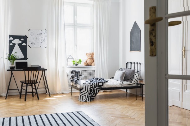 门和地毯在白色的小卧室内部，黑板在床上靠近窗户，海报在书桌上，真实的照片图片下载