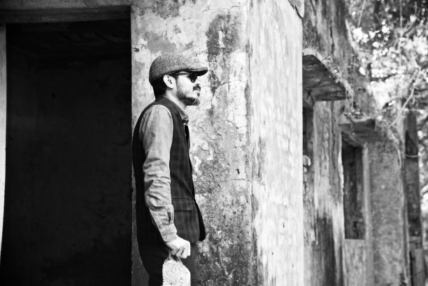 一个戴着帽子的年轻人站在一个废弃的地方图片下载