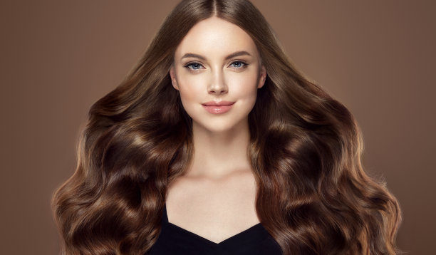 年轻，棕色头发美丽的模型，长，卷曲，整齐的头发。优秀的头发。美发艺术与护发。图片下载