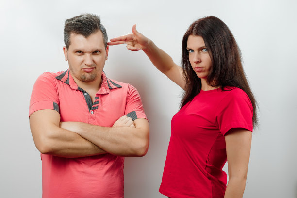 家庭争吵，妻子责骂丈夫，用枪威胁他。家庭关系、婚姻、家庭冲突、图片下载