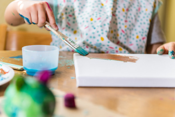 小男孩用画笔彩色地画画素材图片