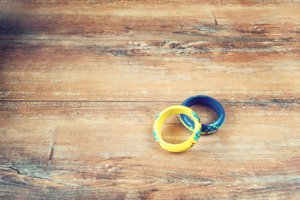 特写图像的黄色和蓝色手镯上的棕色木制背景。图片下载
