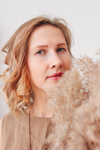 近距离的肖像美丽的年轻女子在亚麻连衣裙与干花，生态自然的美丽概念图片下载