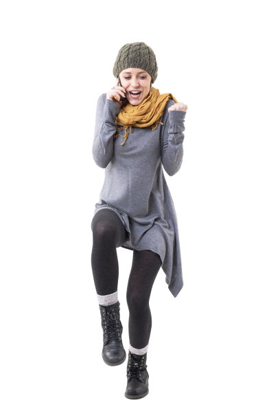 激动激动的年轻时尚的女人在手机庆祝紧握的拳头图片下载