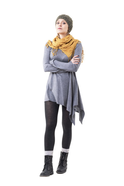 不高兴的年轻可爱的女人在独特的风格的衣服看着相机与交叉的胳膊。图片下载