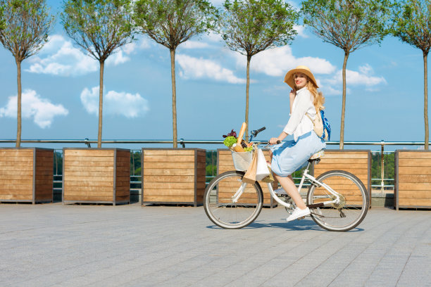 一个穿着蓝色衣服的女人骑着白色的自行车。图片下载