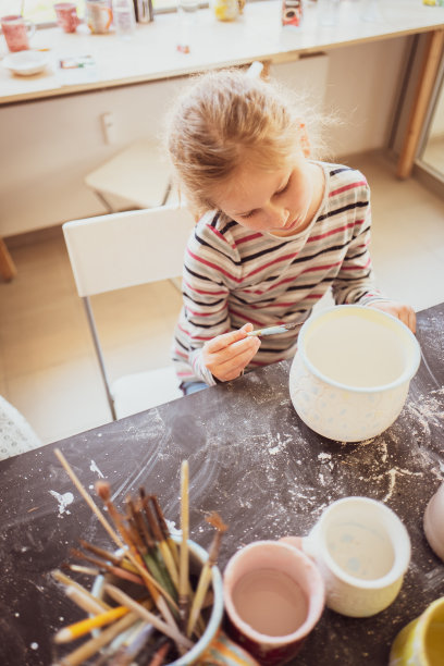 一个女孩正在做一个陶杯图片下载