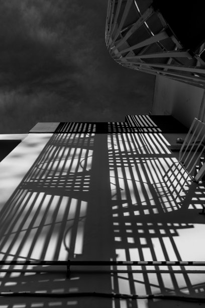 螺旋楼梯的影子投射在混凝土墙上图片下载