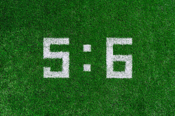 足球比分5:6。白色的数字5和6被画在绿色的草地上，这是创造性的记分牌图片下载