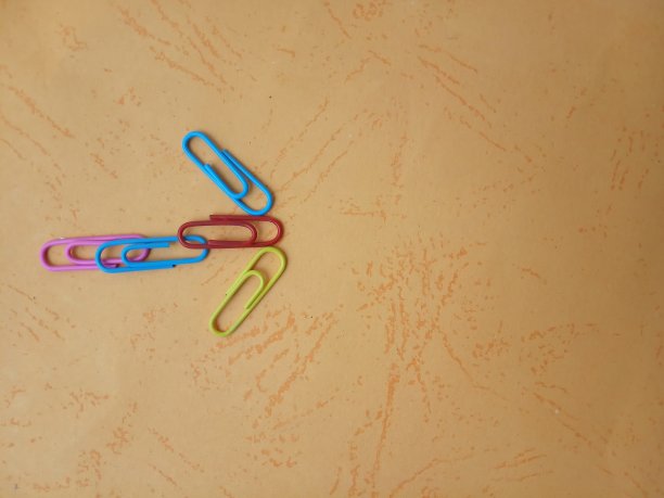 照片平铺橙色纸与红色蓝色黄色回形针箭头形状，为您的背景，背景，消息，引用等图片下载