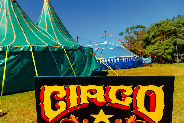黑板上用西班牙语写着“马戏团”，背景是两个帐篷图片下载