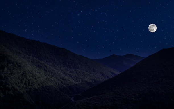 月圆之夜，山路穿过森林。风景优美的夜景乡村小路，夜晚有大月亮。长快门的照片图片下载