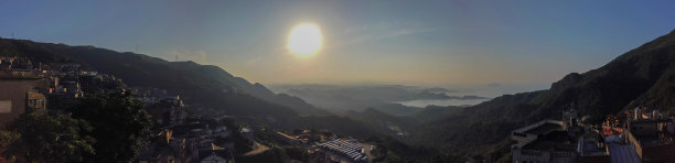 台湾九分城全景住宅和山景与自然融为一体。天空中央有强烈的阳光。图片下载