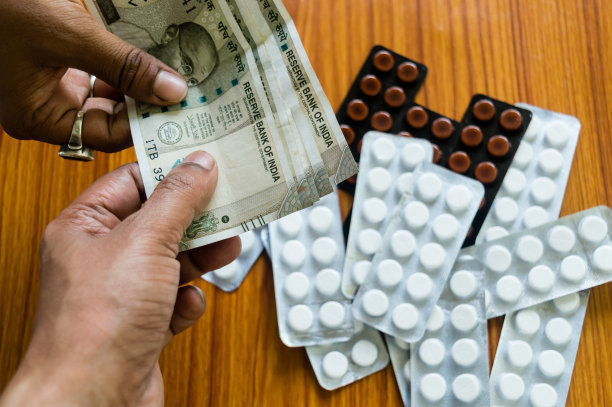 顾客在药店给钱买药。关闭视图。各种胶囊，片剂，药丸在药店的桌子背景。药剂学、医疗保健、高成本用药理念图片下载