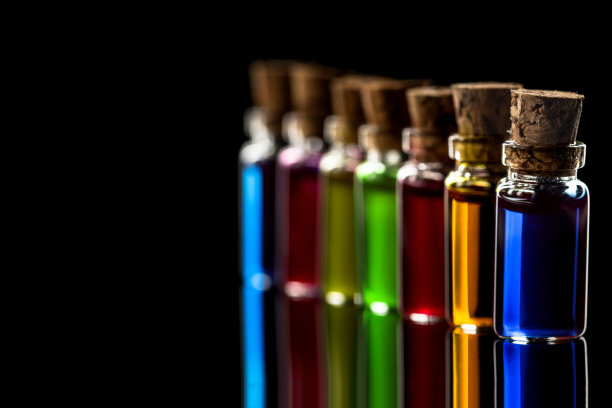 排小瓶与透明彩色化学液体隔离在黑色背景与复制空间图片下载