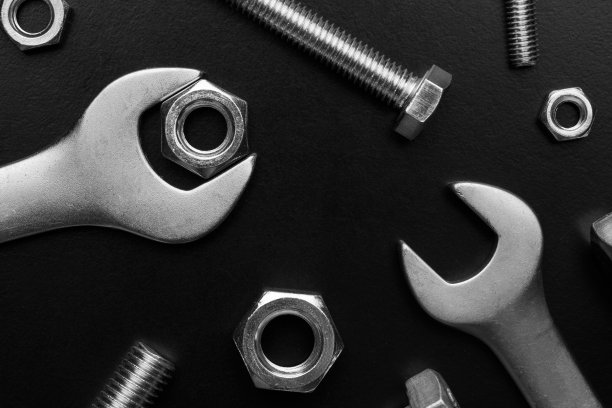 不同尺寸的螺栓和螺母在黑色背景上。图片下载